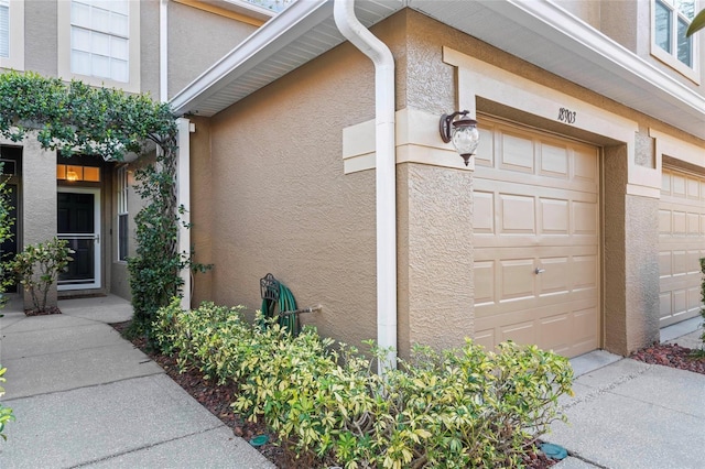 property entrance featuring stucco siding and a garage