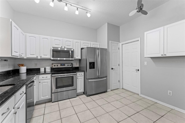 kitchen with light tile patterned floors, decorative backsplash, appliances with stainless steel finishes, and white cabinetry