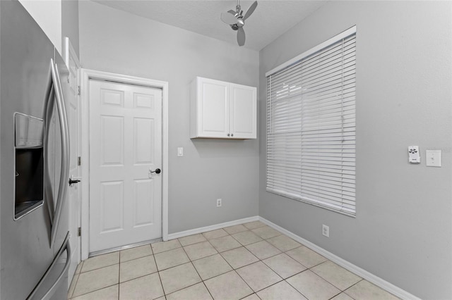 laundry room with light tile patterned floors, baseboards, a textured ceiling, and ceiling fan