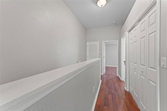 hall featuring dark wood finished floors and baseboards