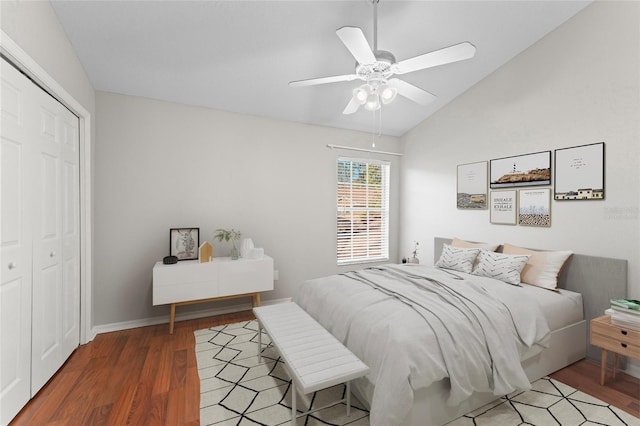 bedroom with wood finished floors, baseboards, ceiling fan, vaulted ceiling, and a closet