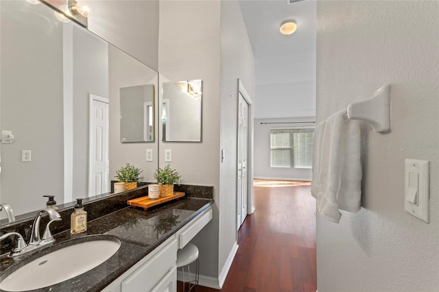 bathroom featuring vanity, wood finished floors, and baseboards