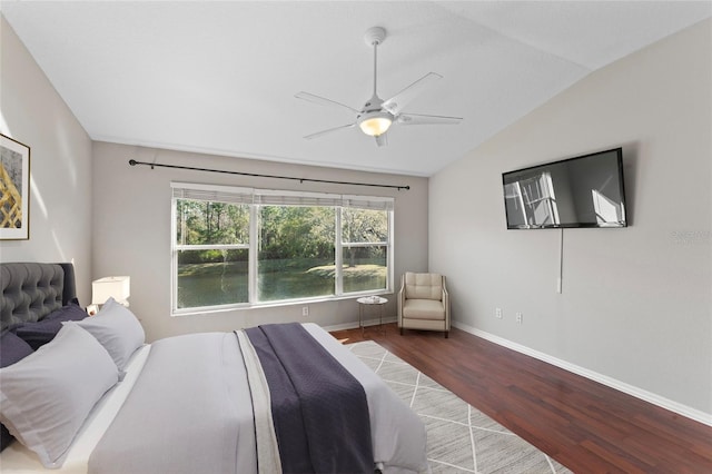 bedroom with baseboards, lofted ceiling, wood finished floors, and a ceiling fan