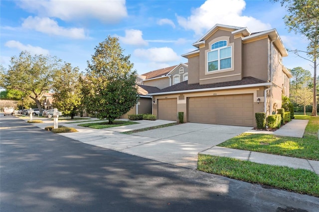 view of front facade featuring stucco siding, driveway, and a garage