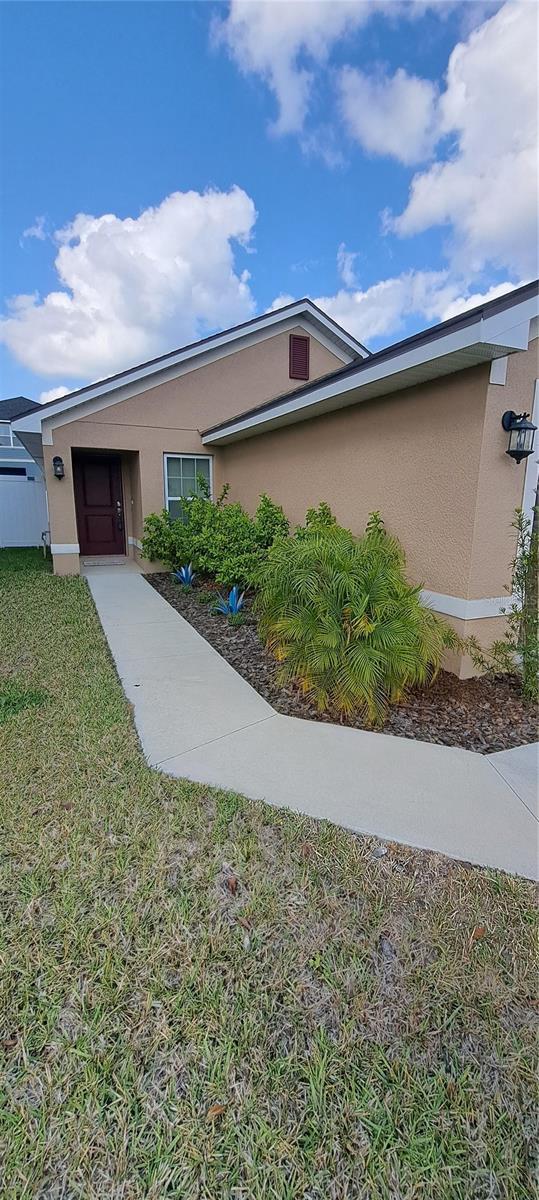 view of side of property featuring stucco siding and a lawn