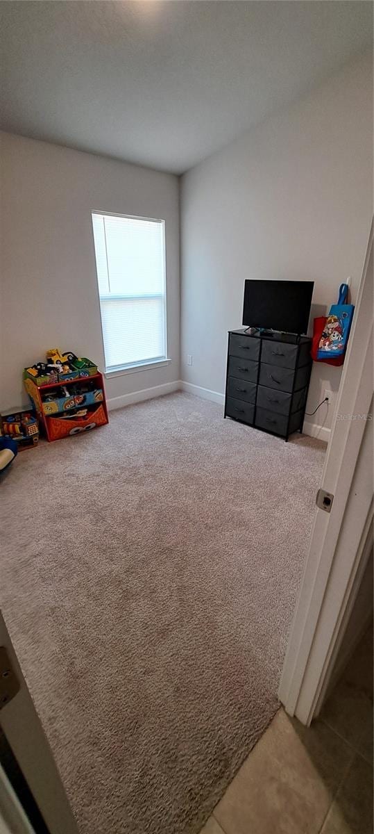 recreation room with carpet and baseboards