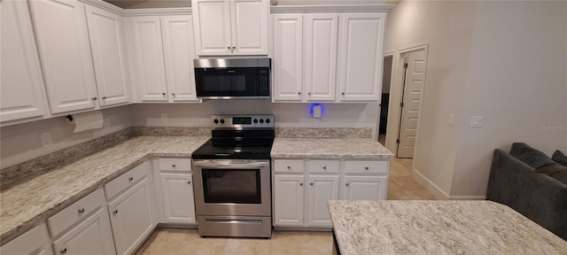 kitchen with white cabinetry, electric stove, and baseboards