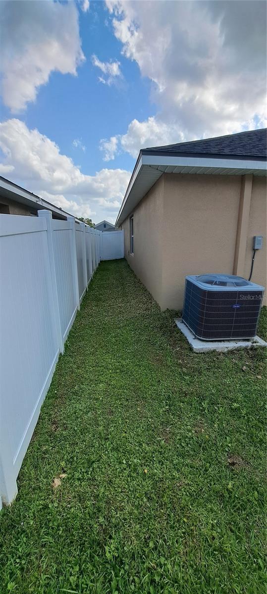 view of yard with central AC unit and a fenced backyard