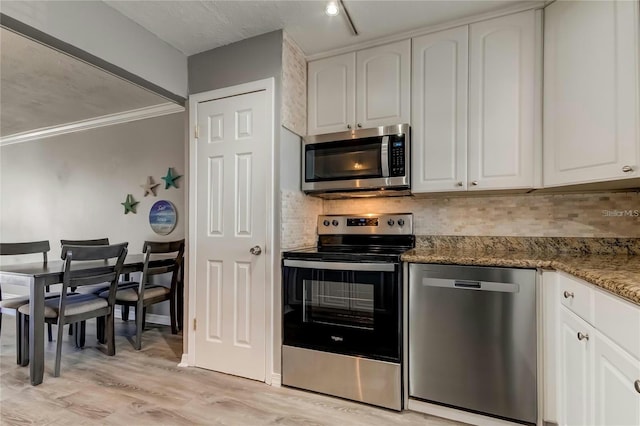 kitchen featuring white cabinets, tasteful backsplash, and stainless steel appliances