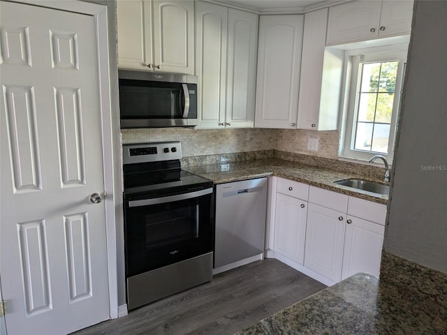 kitchen featuring appliances with stainless steel finishes, white cabinetry, a sink, and dark wood-style floors