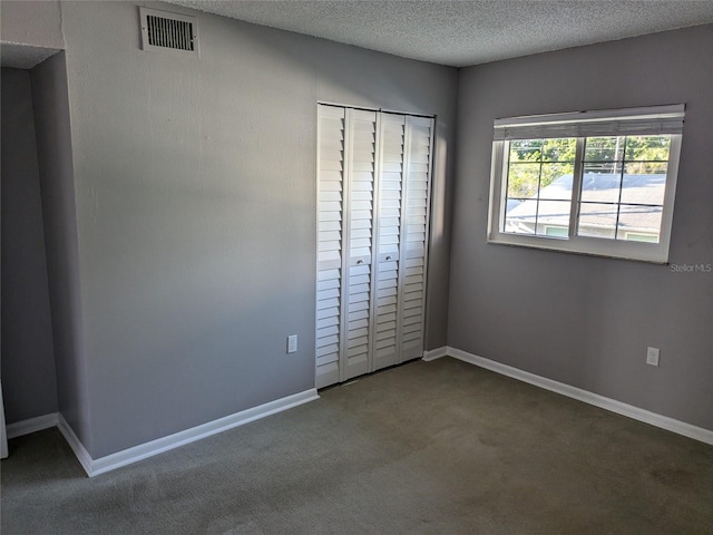 unfurnished bedroom featuring carpet floors, baseboards, visible vents, and a textured ceiling