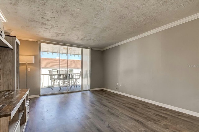 empty room with dark wood-style floors, a textured ceiling, baseboards, and crown molding