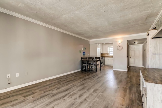 interior space featuring ornamental molding, dark wood finished floors, a textured ceiling, and baseboards