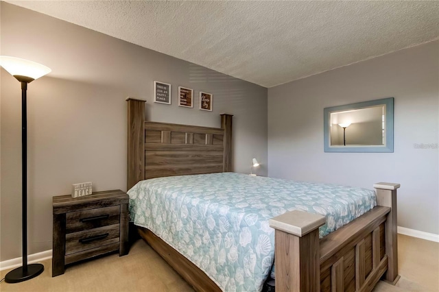 bedroom with baseboards, vaulted ceiling, a textured ceiling, and light colored carpet