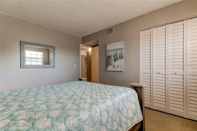 bedroom with carpet floors, a closet, visible vents, and a textured ceiling