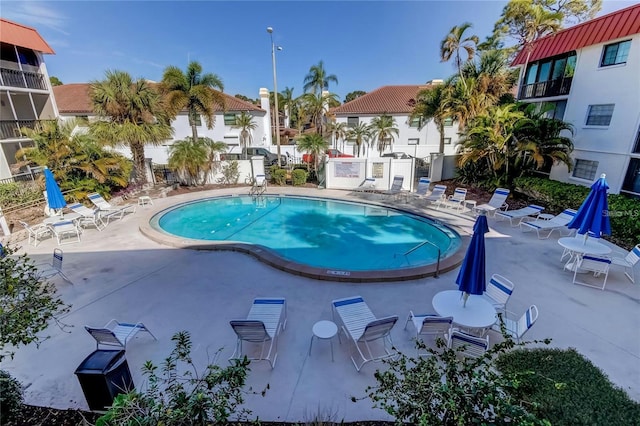 pool with a patio area and fence