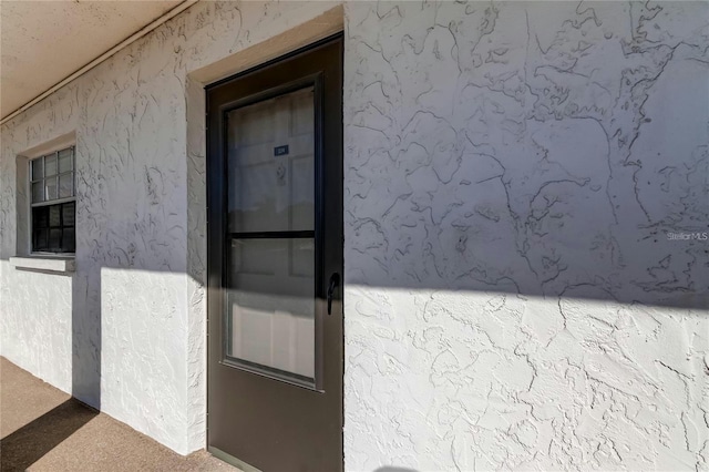 property entrance featuring stucco siding