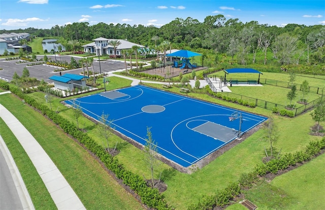 view of sport court with community basketball court, a lawn, fence, and playground community