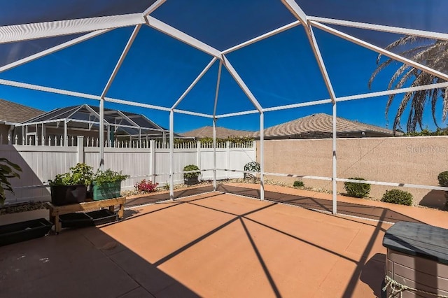 view of patio with glass enclosure and a fenced backyard