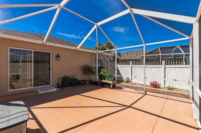 view of patio / terrace featuring glass enclosure and fence