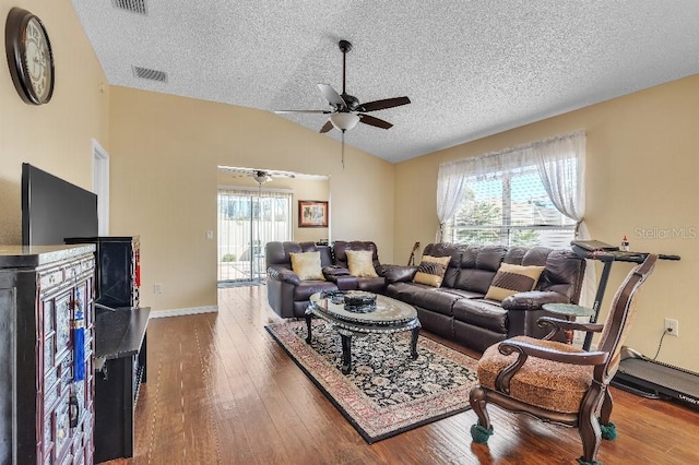 living room featuring visible vents, lofted ceiling, hardwood / wood-style flooring, a textured ceiling, and a ceiling fan