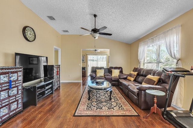 living area with visible vents, a textured ceiling, lofted ceiling, and wood finished floors