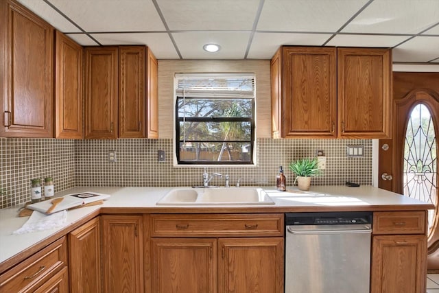 kitchen with dishwasher, light countertops, brown cabinetry, and a sink