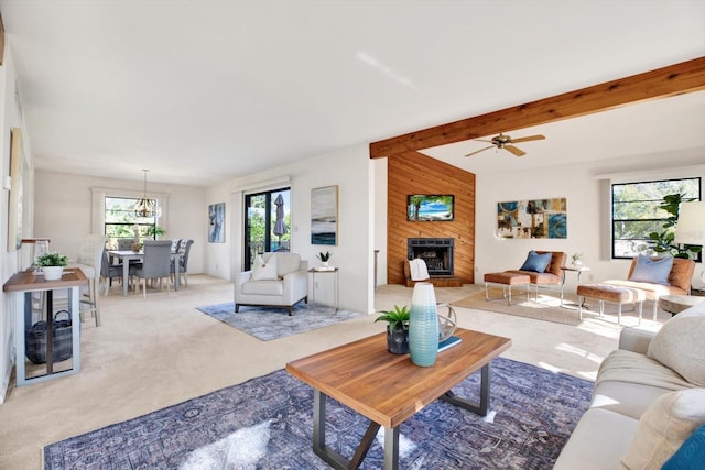 carpeted living room with beam ceiling and a large fireplace