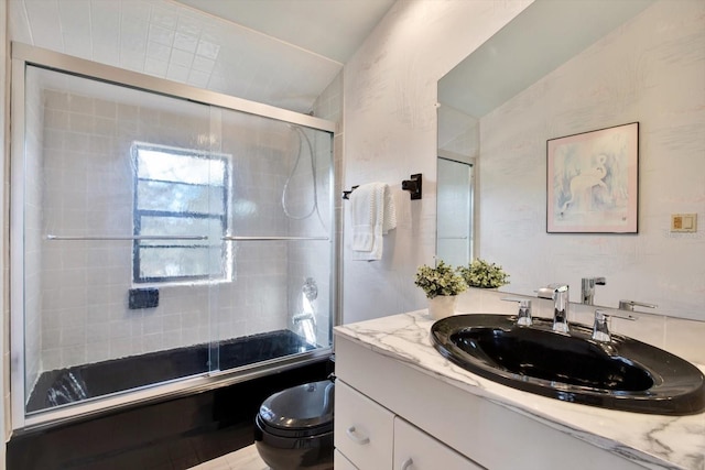 bathroom featuring vanity, toilet, and bath / shower combo with glass door