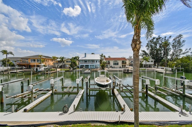 dock area featuring a water view, boat lift, and a residential view