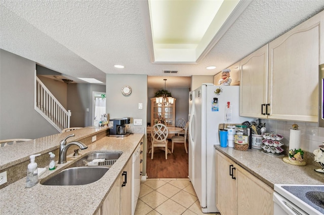 kitchen with a textured ceiling, light tile patterned flooring, a sink, and a notable chandelier