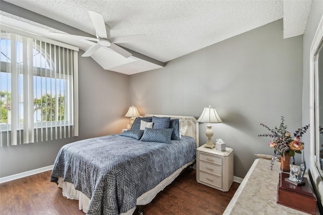 bedroom with ceiling fan, a textured ceiling, baseboards, and wood finished floors