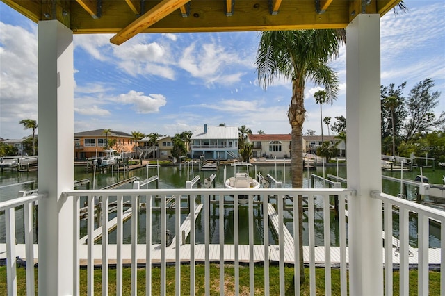 balcony featuring a dock, a water view, and a residential view