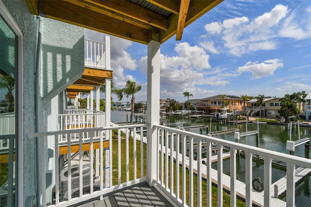 balcony featuring a dock, a water view, and a residential view