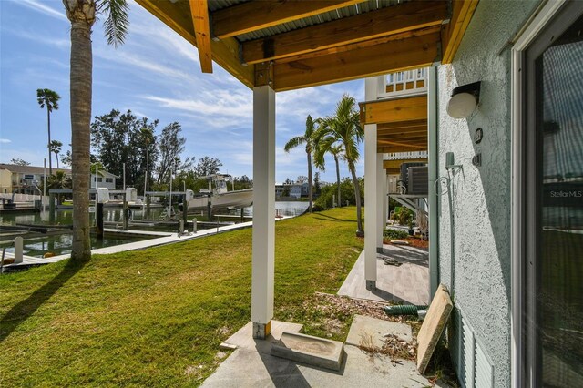 view of yard with a boat dock, a water view, and boat lift