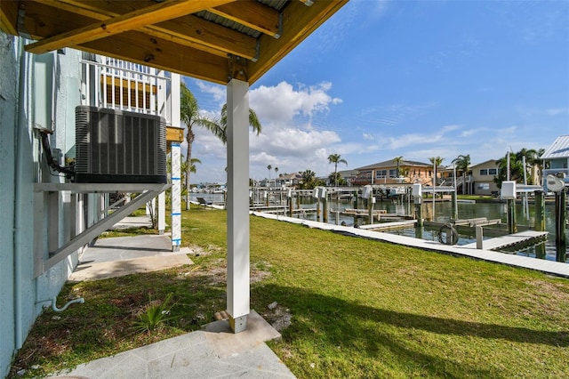 dock area with a water view, boat lift, a residential view, and a yard