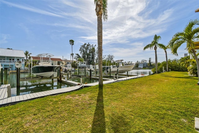 view of dock with a water view, boat lift, and a lawn