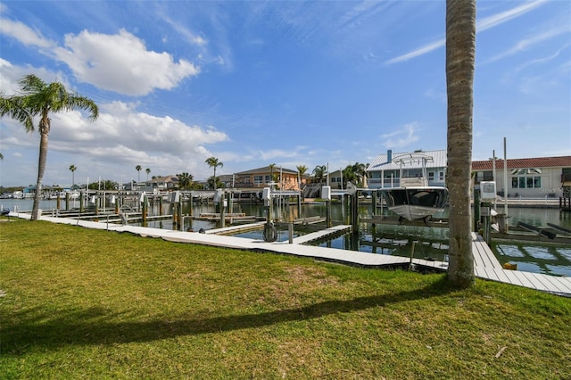 dock area featuring a water view, boat lift, and a yard