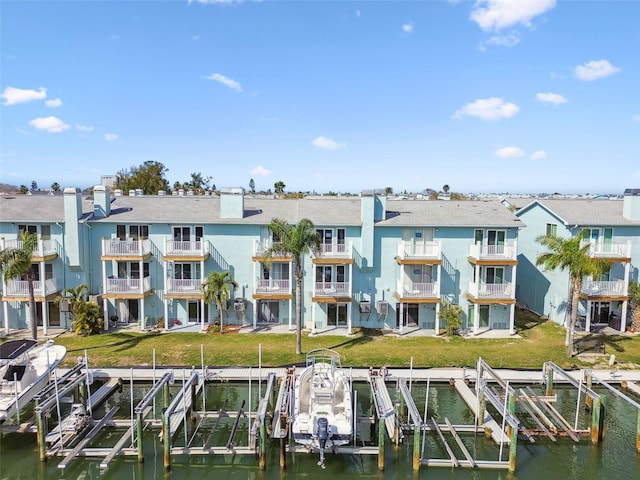 back of property featuring a water view, boat lift, a residential view, and stucco siding