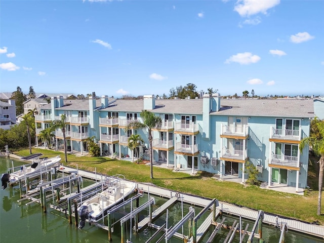 back of house featuring a water view, boat lift, and a residential view