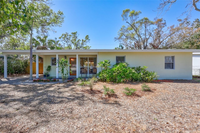 ranch-style home featuring stucco siding and a porch