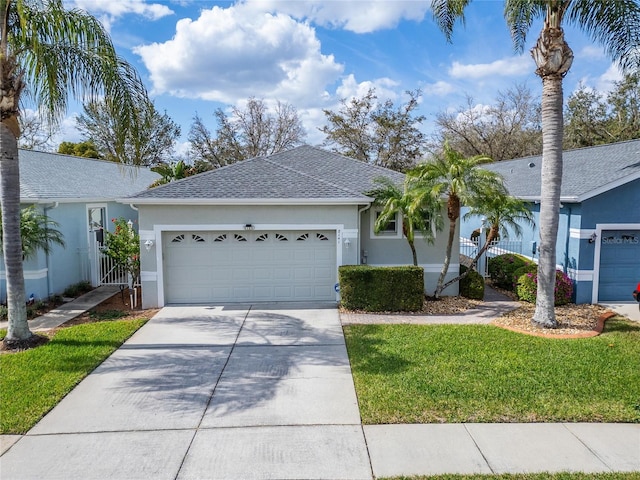 single story home featuring roof with shingles, stucco siding, a front yard, a garage, and driveway