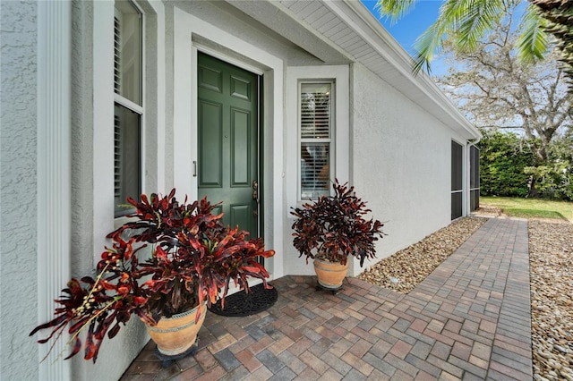 view of exterior entry featuring stucco siding