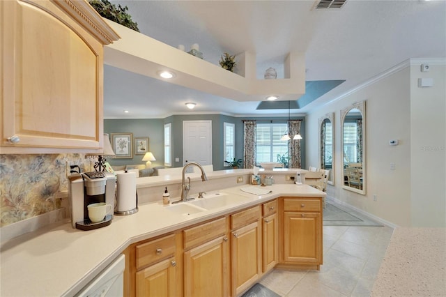 kitchen featuring crown molding, light countertops, light brown cabinets, and a sink