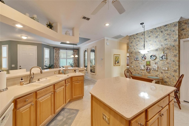 kitchen with a sink, white dishwasher, visible vents, and crown molding