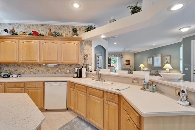 kitchen featuring white dishwasher, a peninsula, a sink, light countertops, and ornamental molding