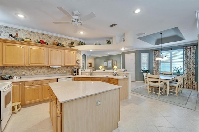 kitchen featuring a center island, visible vents, light brown cabinetry, white appliances, and a peninsula