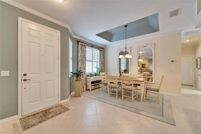 dining area featuring light tile patterned floors, visible vents, baseboards, a tray ceiling, and crown molding