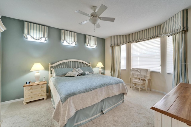 carpeted bedroom with ceiling fan, a textured ceiling, and baseboards