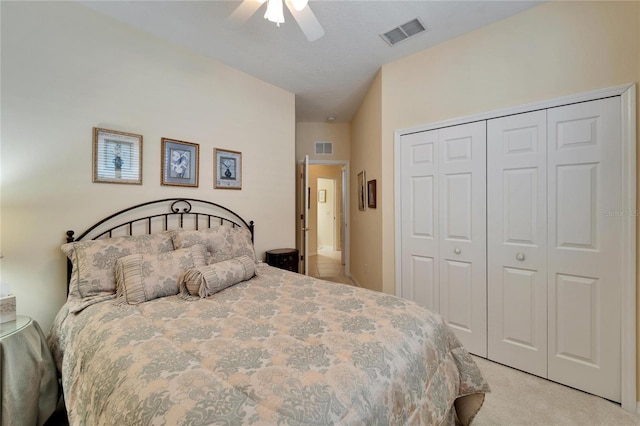 bedroom featuring a ceiling fan, a closet, visible vents, and light colored carpet